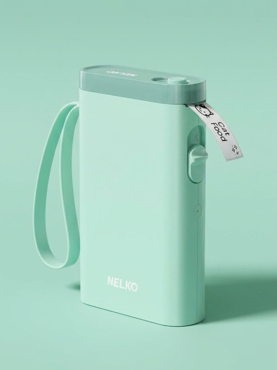 A mint green NELKO portable label maker with a darker sage green top and matching wrist strap, printing a white label with 'Cat Food' and a cat icon.