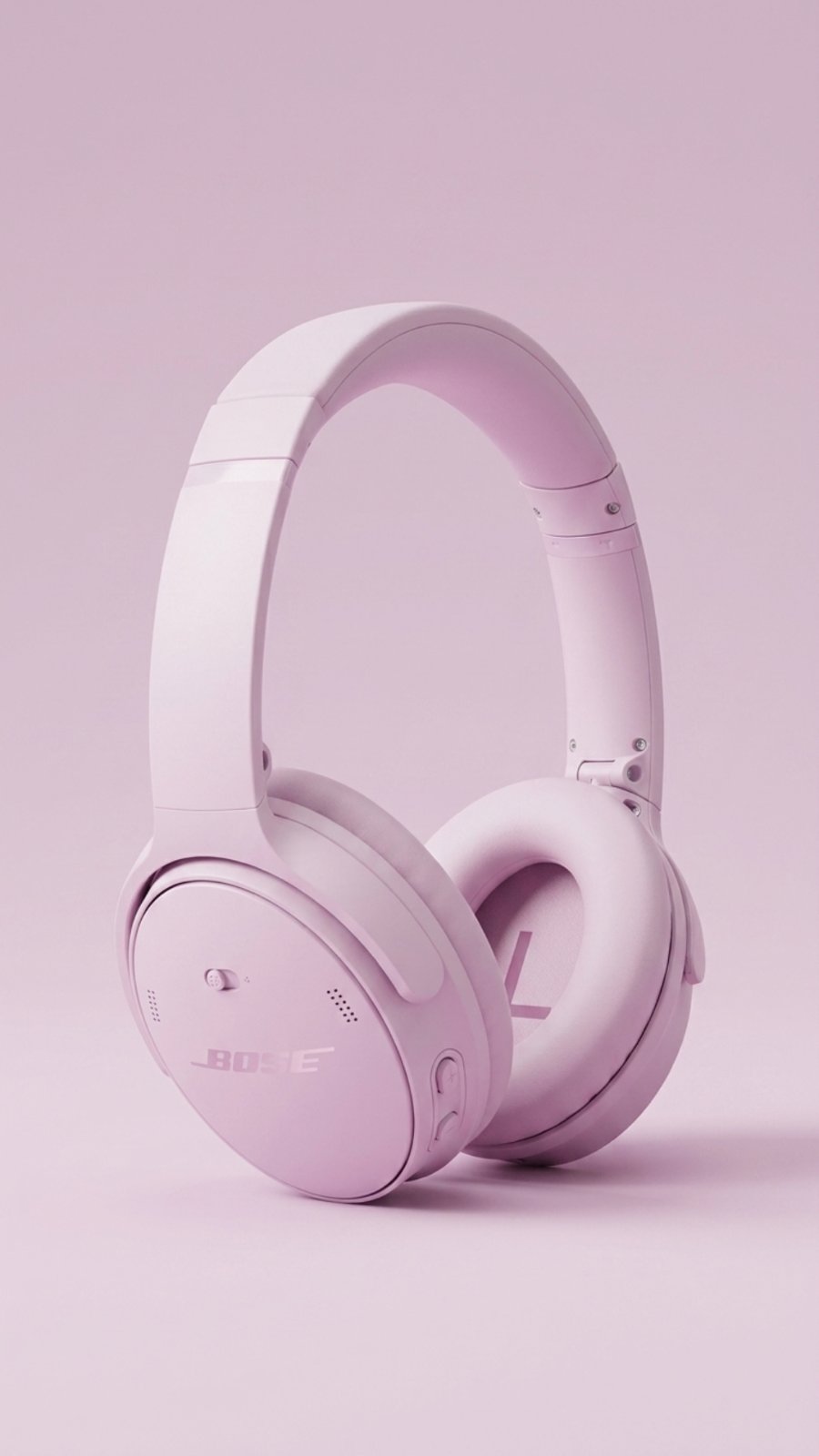 A pair of over-ear headphones in a solid pale lilac color, shown standing upright on a matching lilac background.