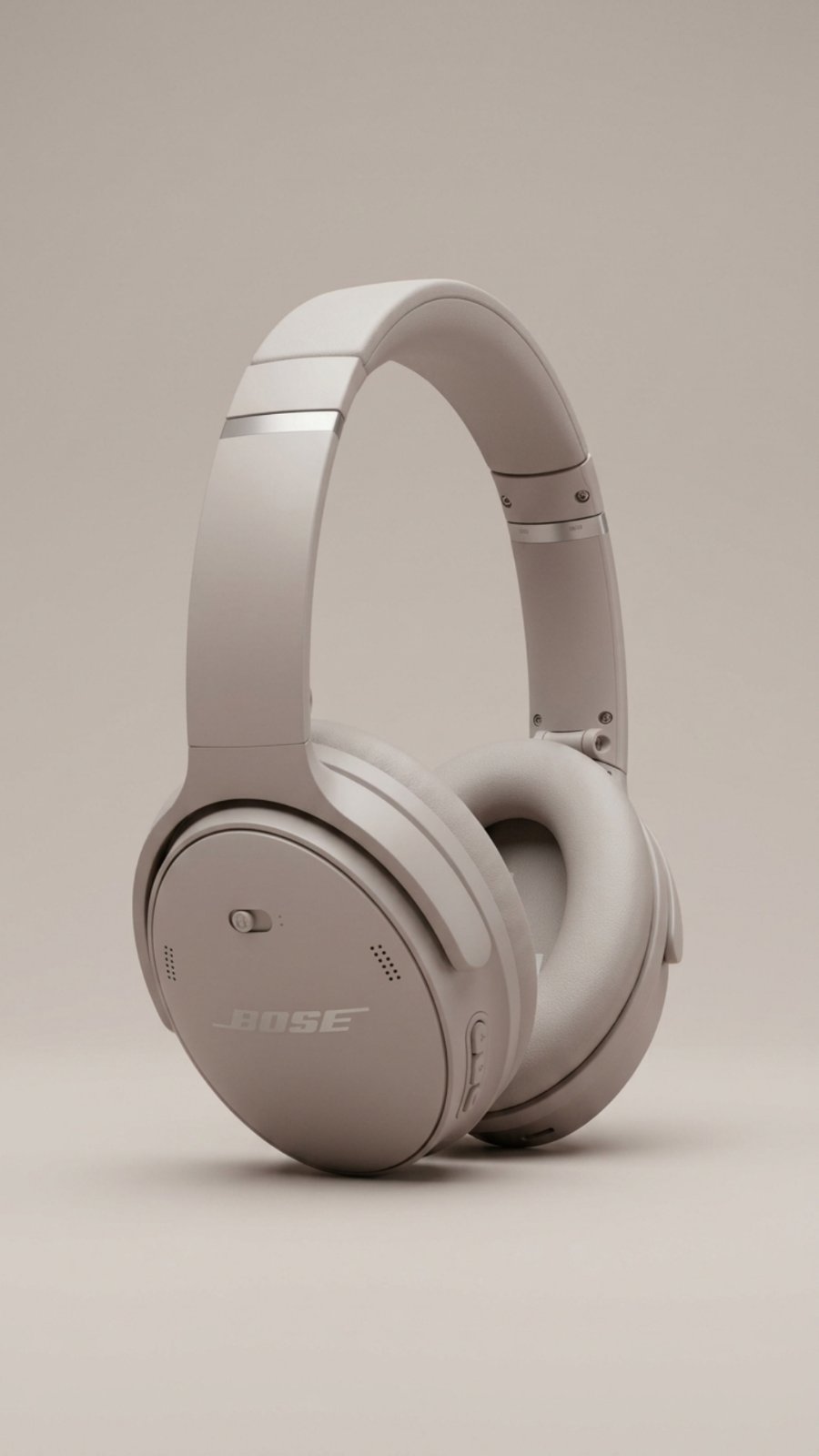 A pair of Bose QuietComfort Wireless Headphones in a light off-white color, shown against a matching light beige background.