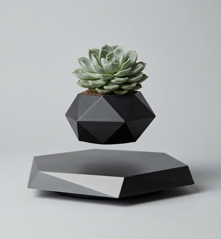 A matte black faceted geometric plant pot containing a green succulent hovers in mid-air above a matching low hexagonal base on a neutral grey background.