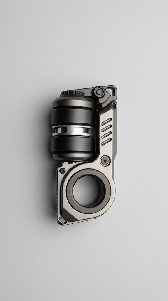 A small grey metal fidget spinner resting on a light wood surface, with clean geometric edges and a matte finish.